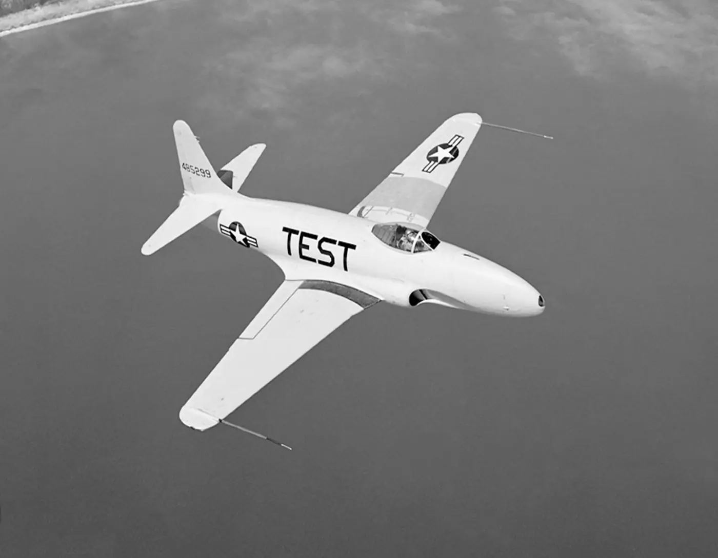 A white P-80A marked TEST banking over water