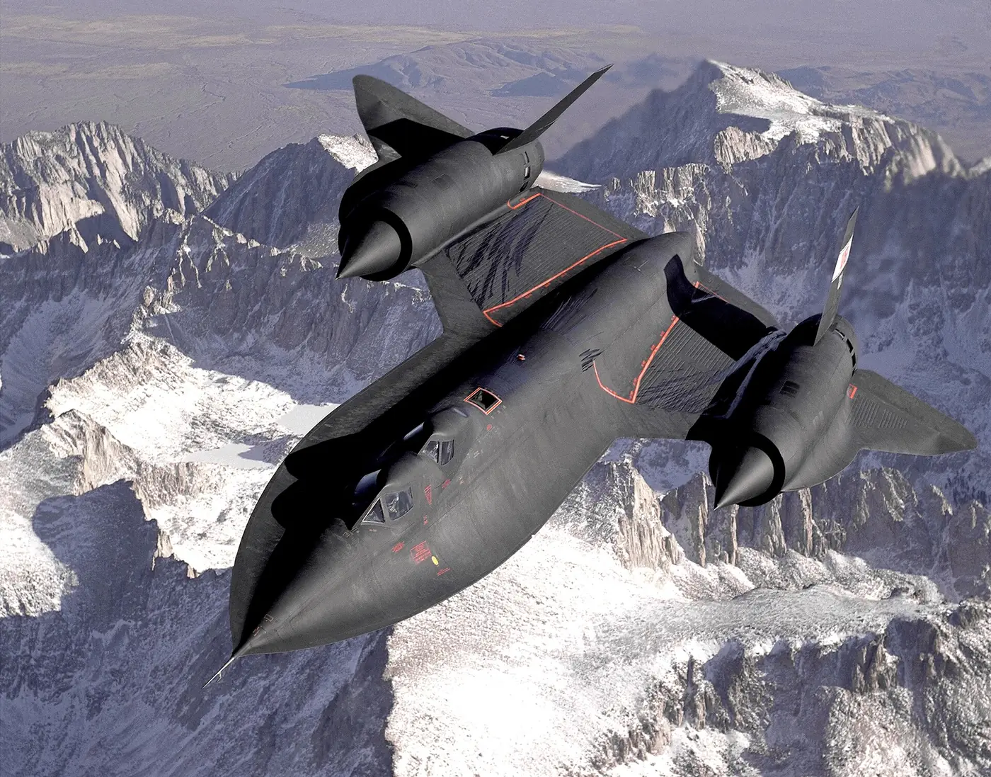 A black SR-71 Blackbird seen from above over snow-covered mountains